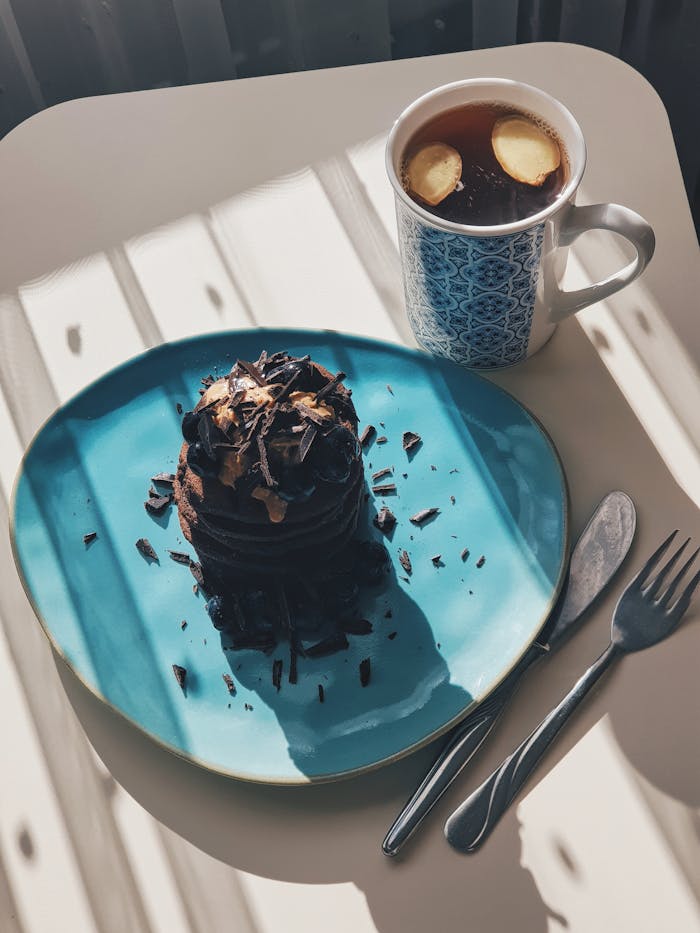 A plate with a chocolate cake and a cup of coffee